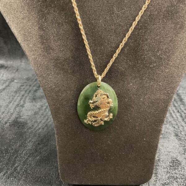 Vintage Chinese green jade pendant necklace with dragon detail.