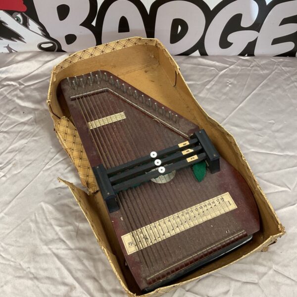 Vintage chord harp musical instrument with buttons and strings.