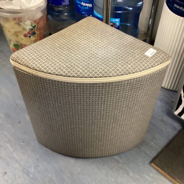 Vintage wicker corner wash bin for laundry storage.