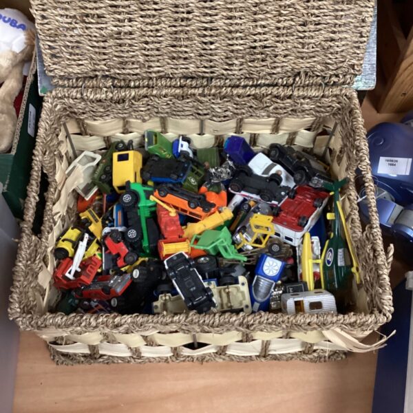 Wicker basket filled with a vintage diecast vehicle lot.
