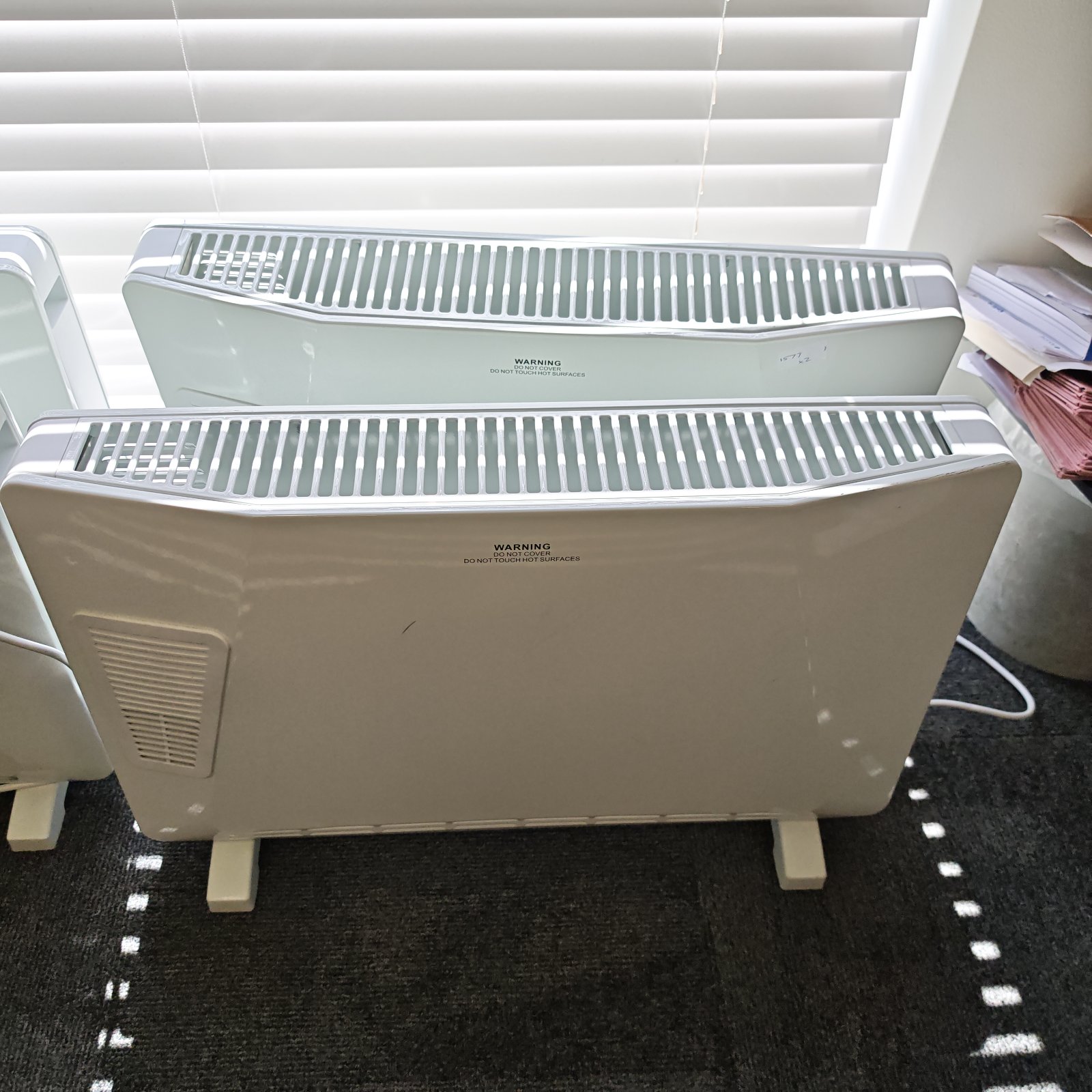 Two vintage electric heaters with fan-forced design.