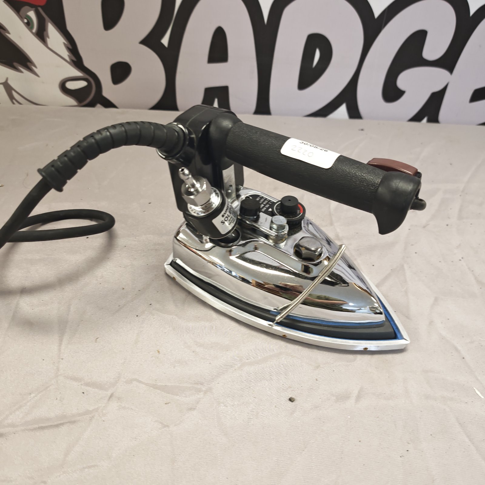 Vintage Eunsung steam iron with black handle and metal body.