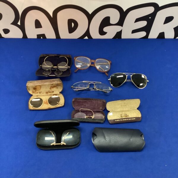 Vintage eyeglasses lot with replica Ray-Ban sunglasses on display.