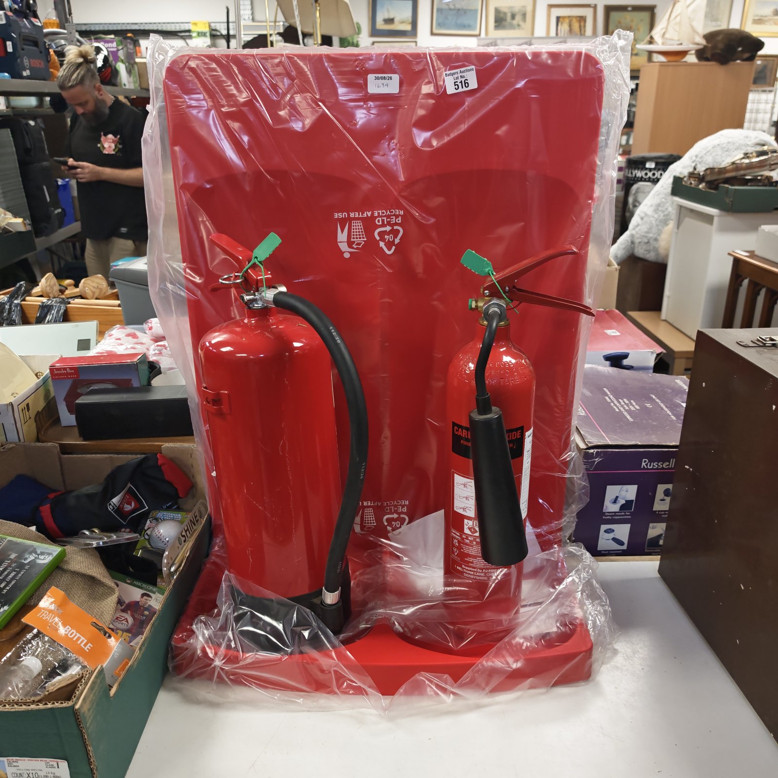 Red vintage fire extinguisher with black handle and nozzle.