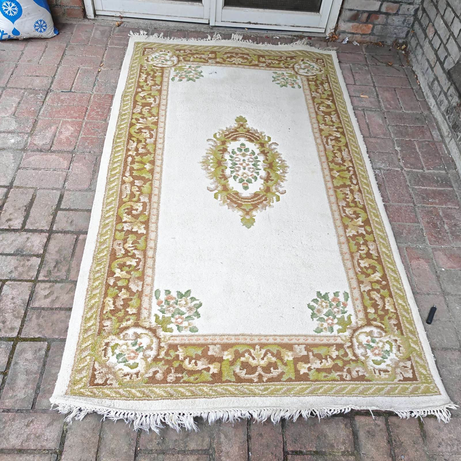 Vintage cream floral rug with a patterned design.