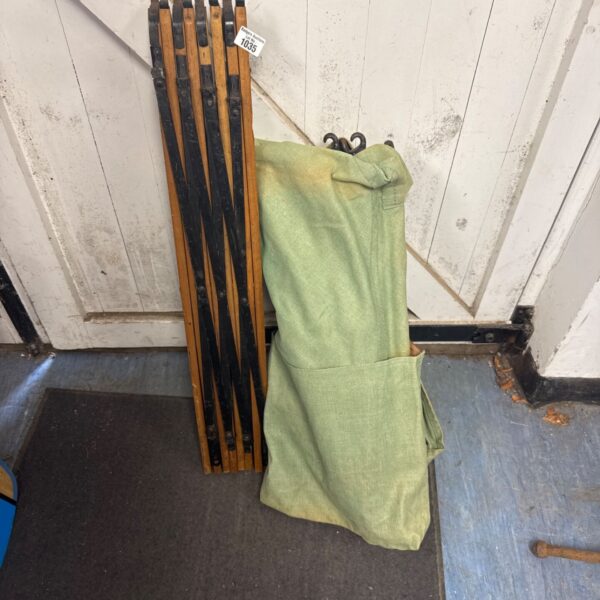 Vintage wooden framed folding camp bed with green canvas.