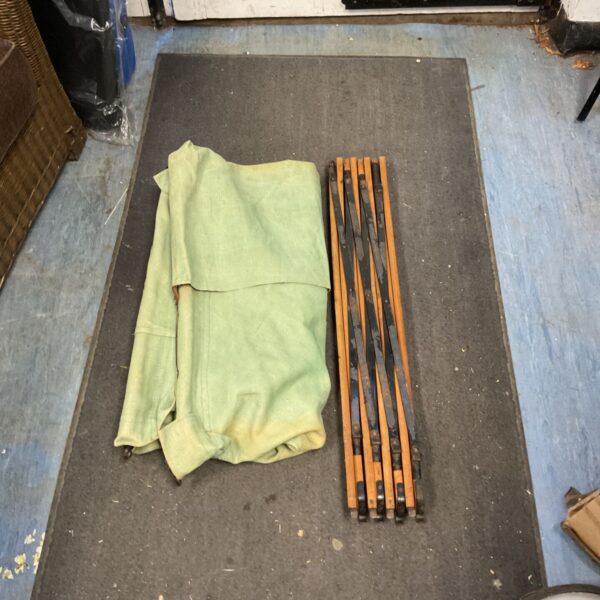 Vintage folding camping bed with canvas and wooden frame.