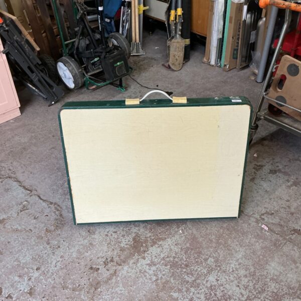 Vintage green folding table in a cluttered garage setting.