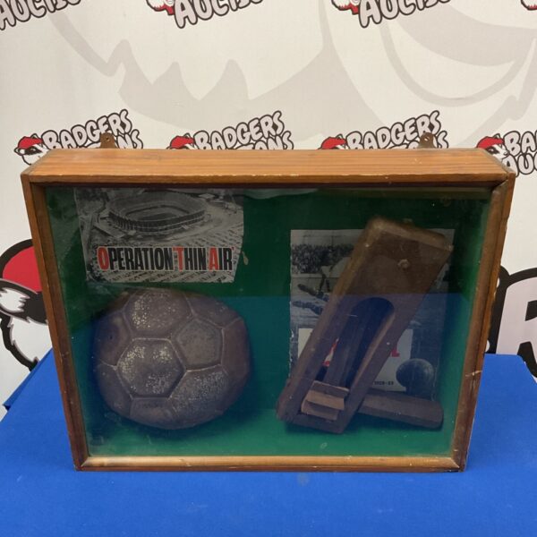 Vintage football and clacker in glass display case.