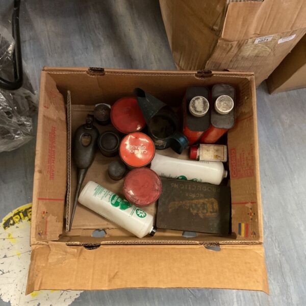 Vintage garage lot with various tins and cans for automotive use.