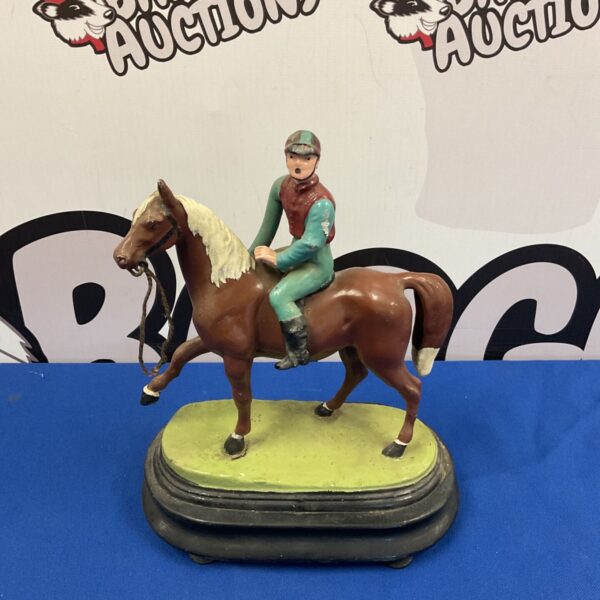 Vintage cast metal horse and jockey sculpture, detailed equestrian figurine.