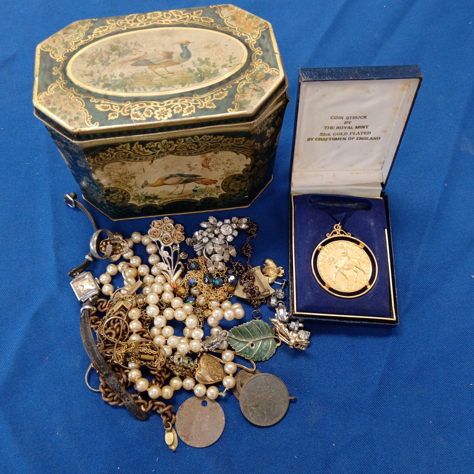 Vintage jewellery lot in decorative tin with pearl necklace and brooches.