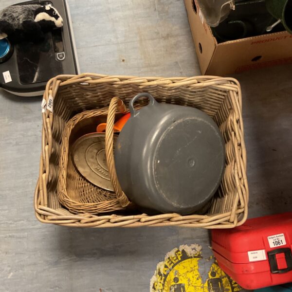 Vintage kitchen pots in a woven basket, rustic enamel cookware.
