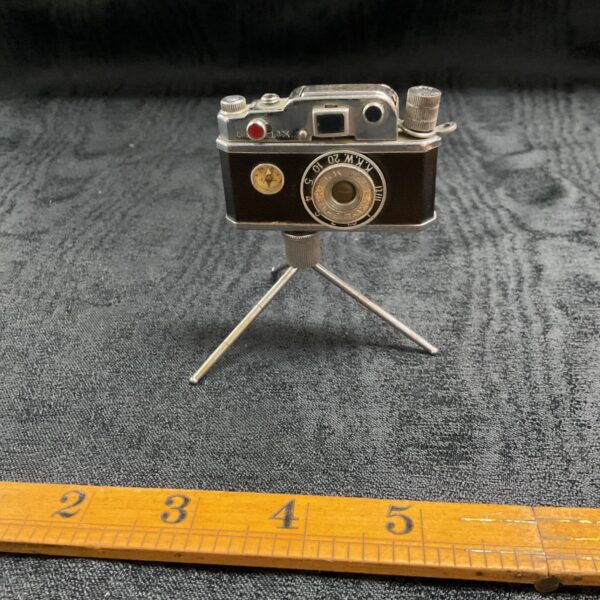 Vintage K.K.W. camera lighter on a ruler.