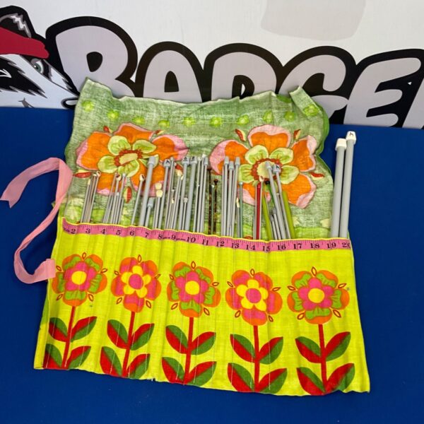 Vintage knitting needles in a colorful floral case.