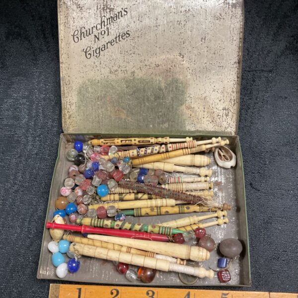 Vintage lace making bobbins in a Churchman’s cigarette tin.