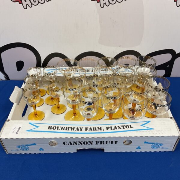 Vintage liqueur glasses on a tray with amber stems and gilded ivy.