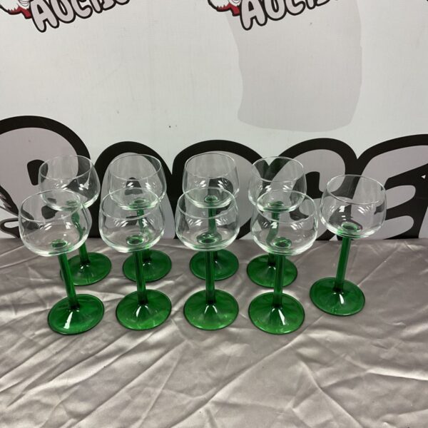Set of nine vintage Luminarc emerald green wine glasses on display.