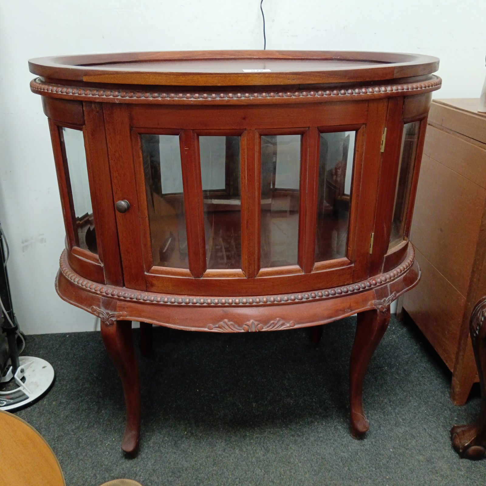 Vintage mahogany oval drinks cabinet with bevelled glass panels.