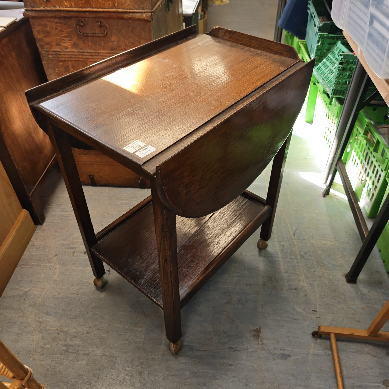 Vintage mahogany drop leaf table with casters, side view.