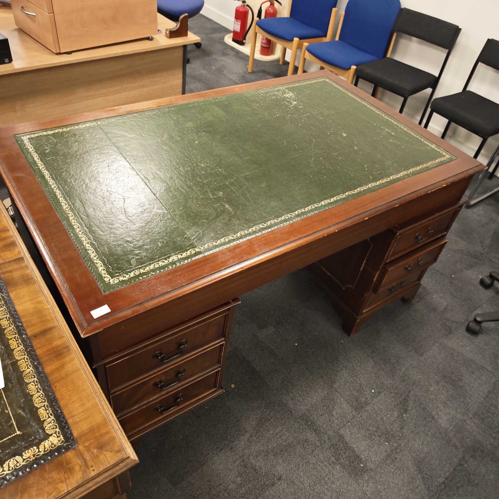 Vintage mahogany partners desk with green leather writing surface.