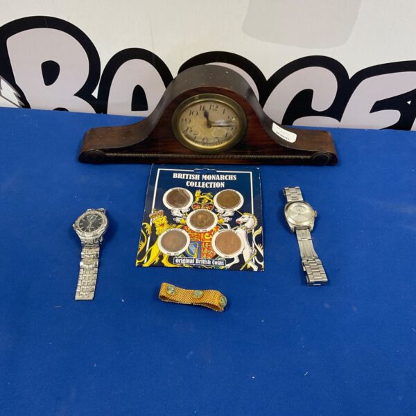 Vintage mantle clock with coins and watches, a collectible display.