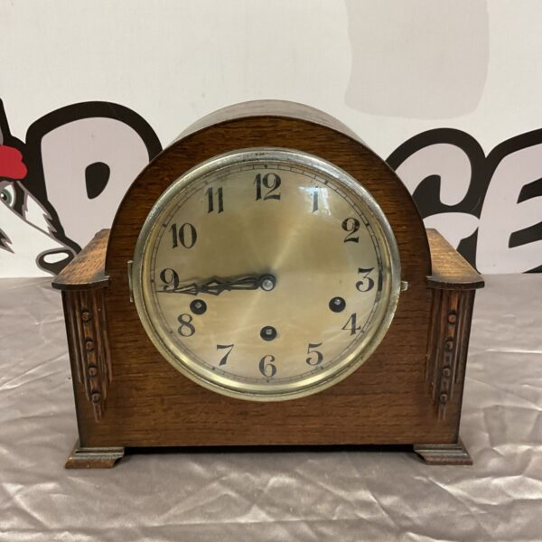 Vintage art deco mantle clock with a circular dial.
