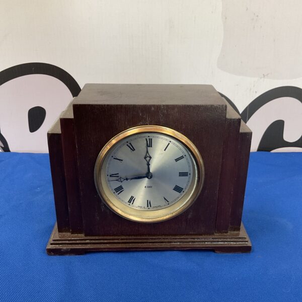 Vintage wooden mantle clock with Roman numeral dial.
