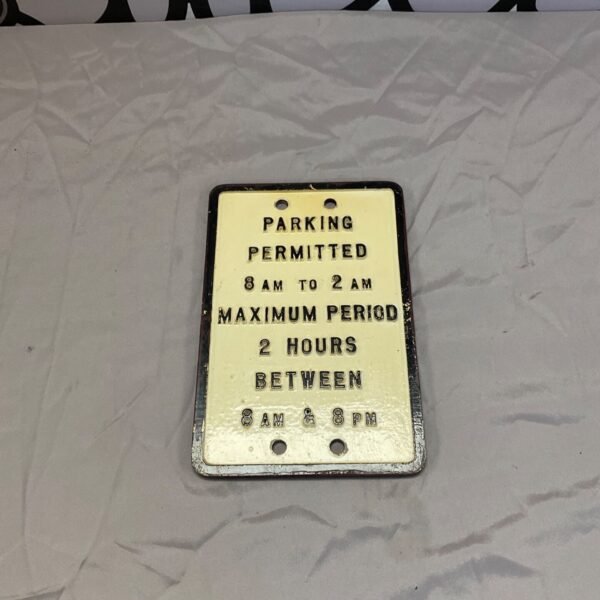 Vintage metal parking permitted sign with 8 AM to 2 AM hours.