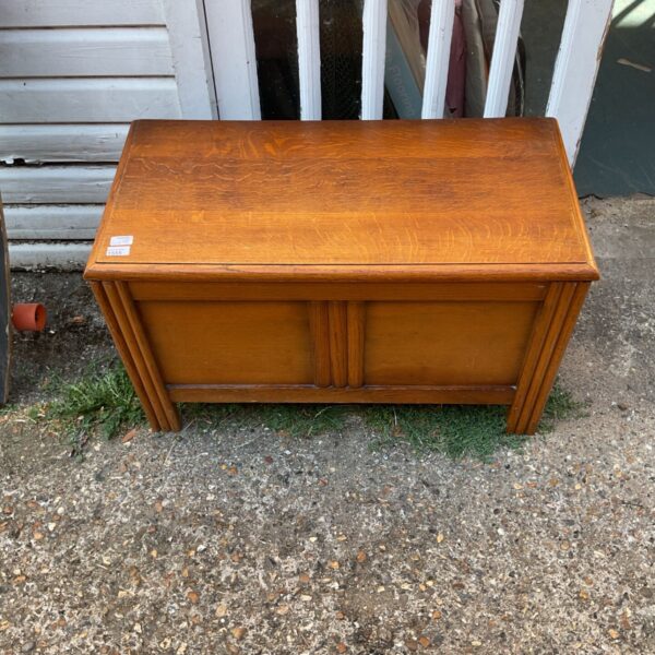Vintage oak blanket box with paneled front and hinged lid.