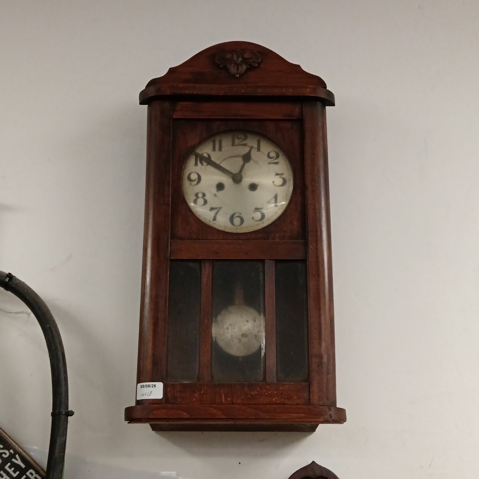 Vintage oak wall clock with Roman numerals, a classic timepiece.