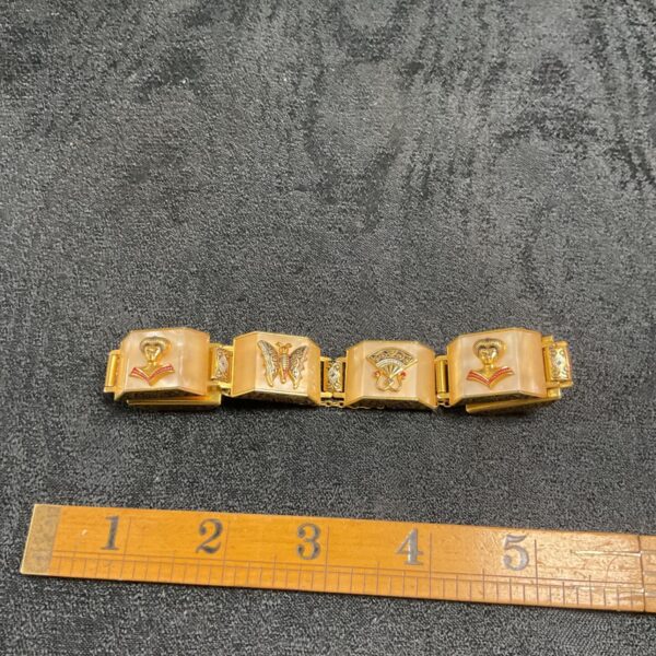 Vintage Persian bracelet with decorative links and ruler for scale.