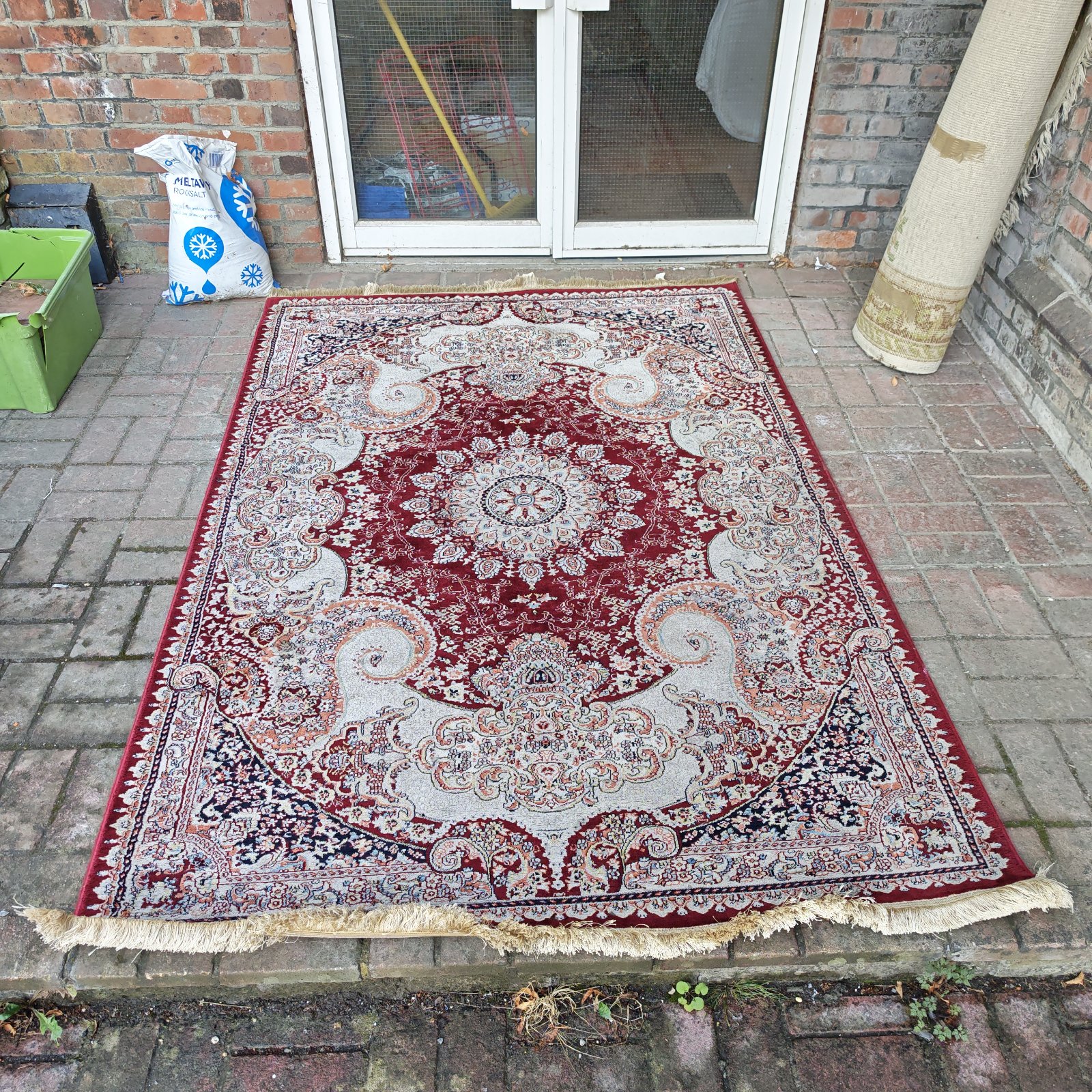 Detailed view of a vintage red Persian rug with floral patterns.