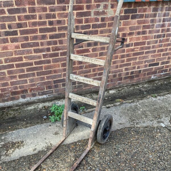 Vintage sack barrow with wooden frame and cast iron wheels.
