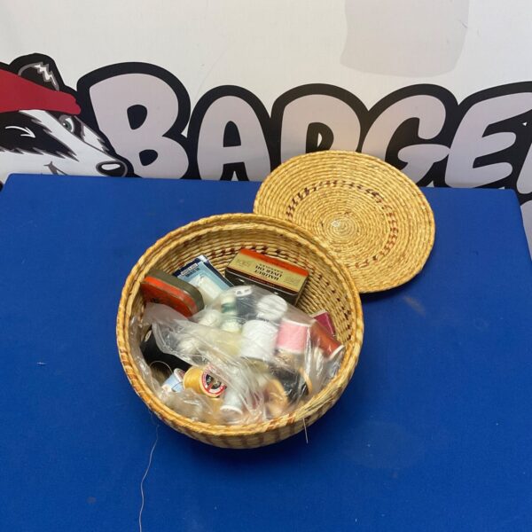Vintage sewing basket filled with colourful thread spools.