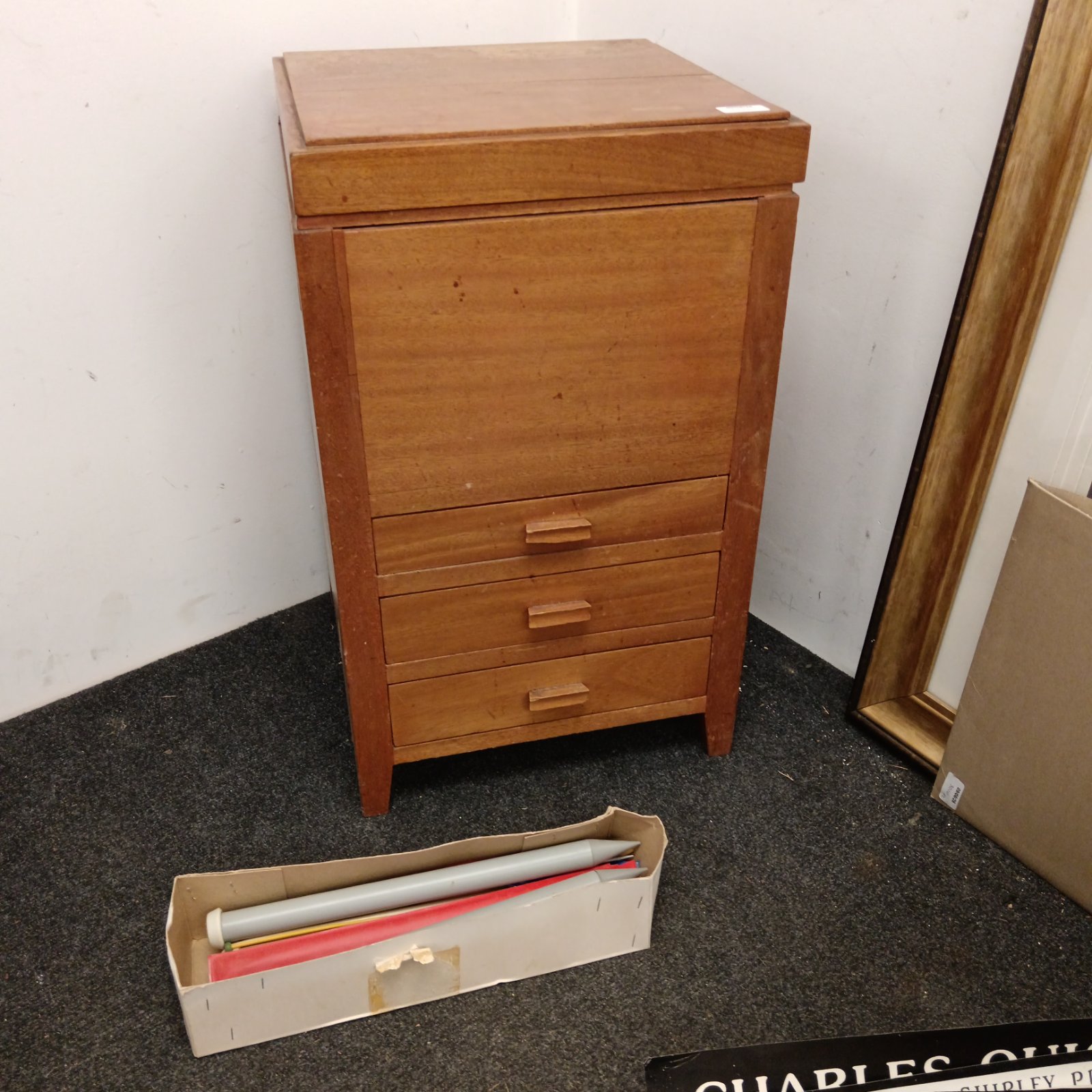 Vintage wooden sewing cabinet with four drawers and lift-top.