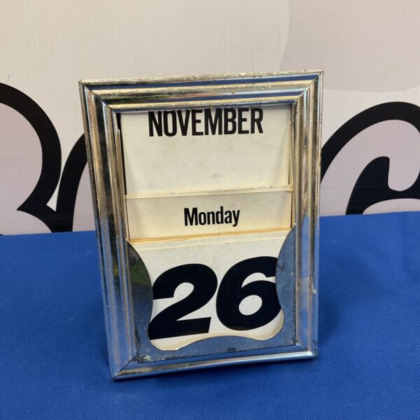 Vintage silver plate desk calendar showing the date.
