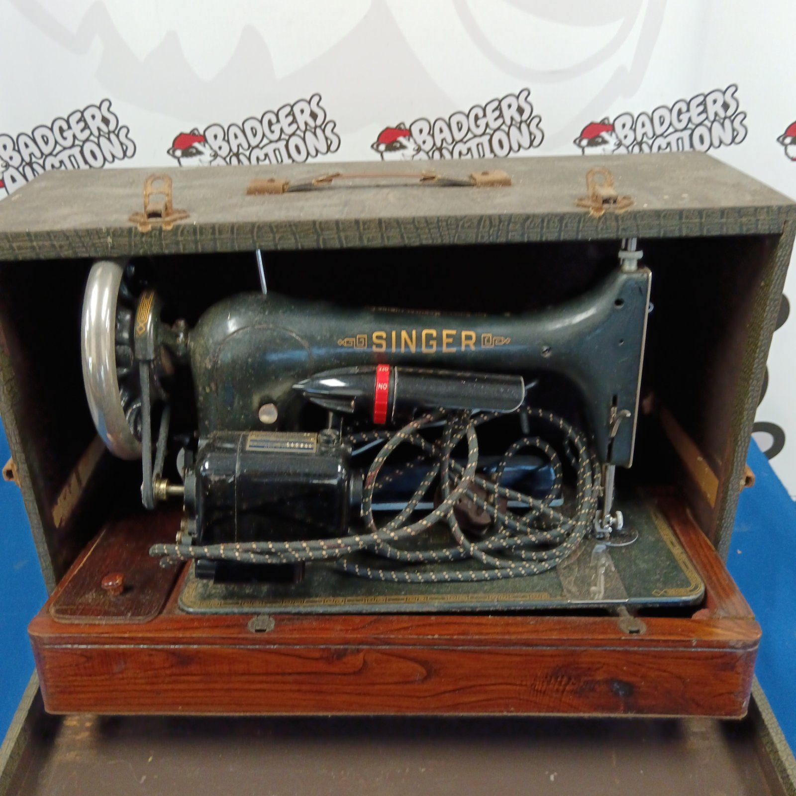 Vintage Singer sewing machine in wooden case with foot pedal.