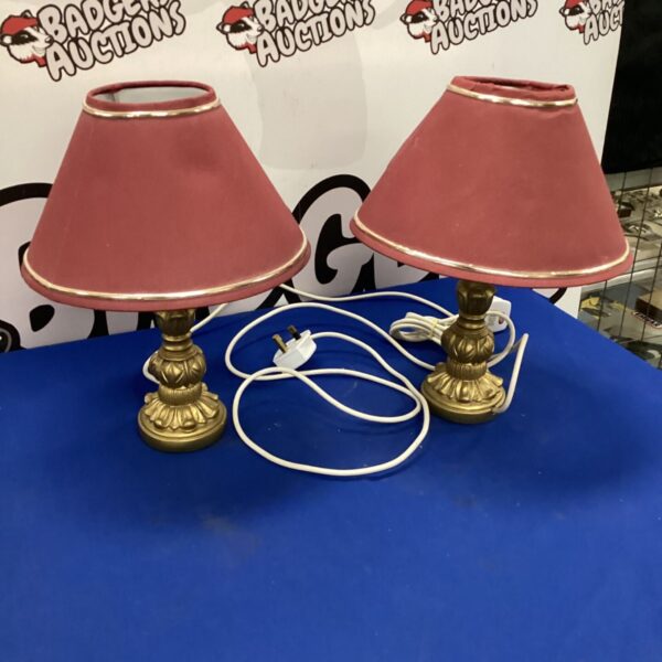 Pair of vintage table lamps with pink shades and brass bases.