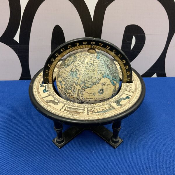 Vintage tabletop world globe with zodiac symbols and old world map.