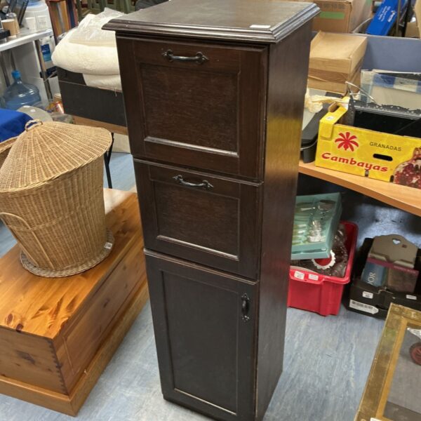Dark wood tall boy drawer cabinet with multiple drawers.