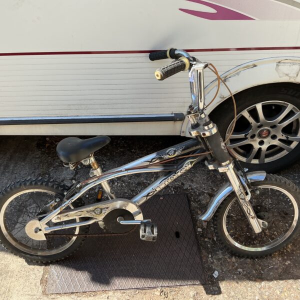 Vintage Triumph BMX bicycle with chrome frame and flame decals.