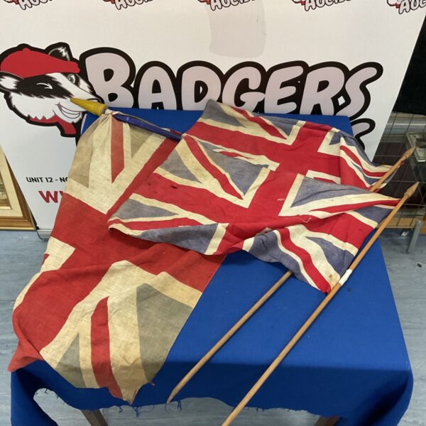 Lot of three vintage Union Jack flags displayed indoors.