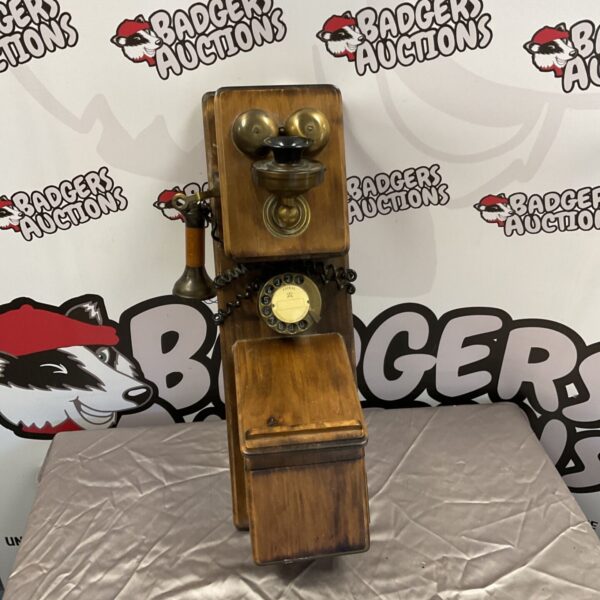 Reproduction vintage wall telephone with wooden casing and dial.
