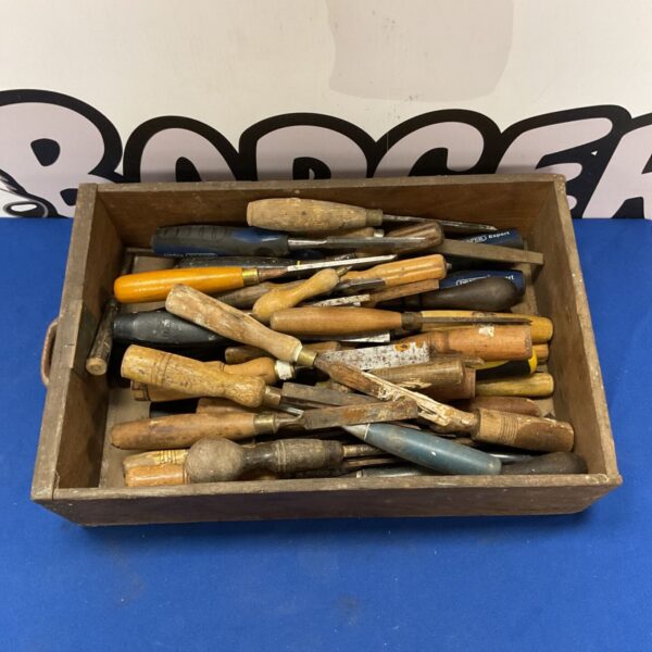 Vintage crate filled with assorted wood carving chisels.