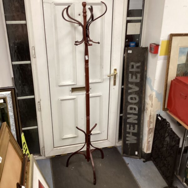 Vintage wooden coat and boot stand in a hallway setting.