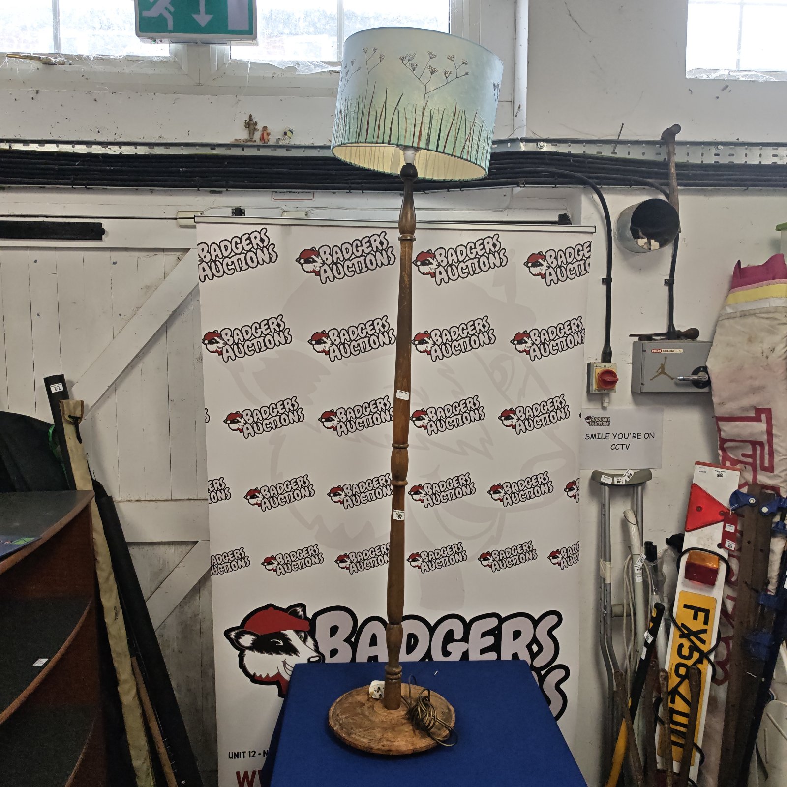 Vintage wooden standard lamp with green shade, retro home lighting.