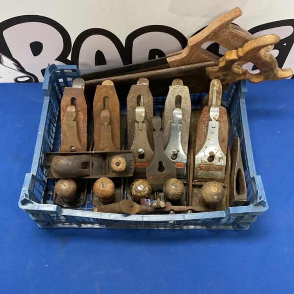 Vintage woodworking hand planes in a metal lot.