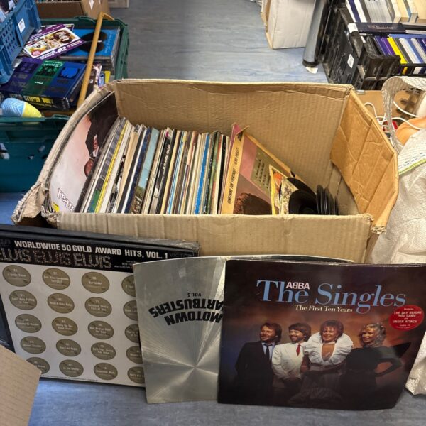 Mixed lot of 12” vinyl records in a cardboard box.