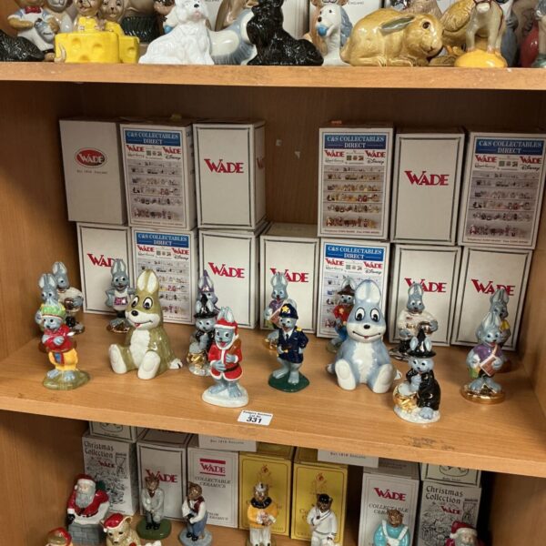 Collection of vintage Wade collectable ceramic figures on display.